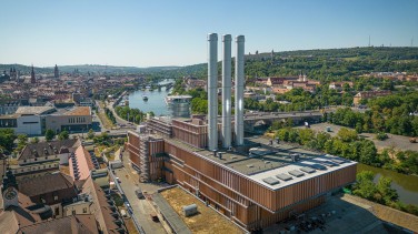 Industrielle Rohrleitungen im Freien, im Hintergrund ein Strommast